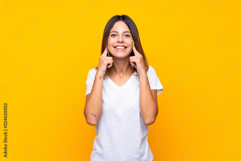 Young woman over isolated yellow background smiling with a happy and pleasant expression Young woman over isolated yellow background smiling with a happy and pleasant expression