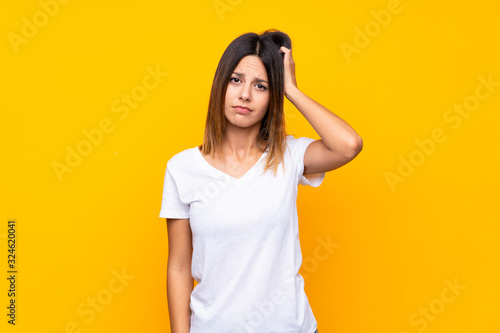 Young woman over isolated yellow background with an expression of frustration and not understanding