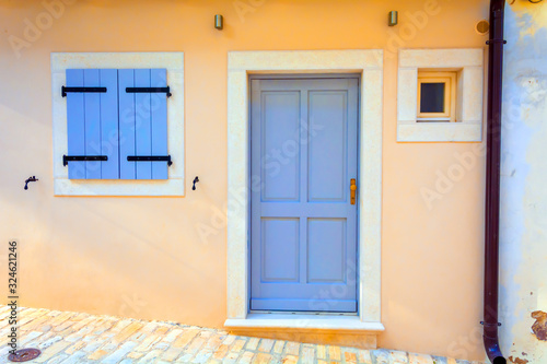 Facade of an old house with blue door and shutters. Croatia