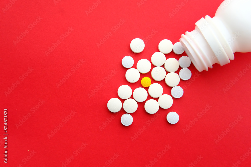 Close up of pills on table on red background Close up of pills on table on red background