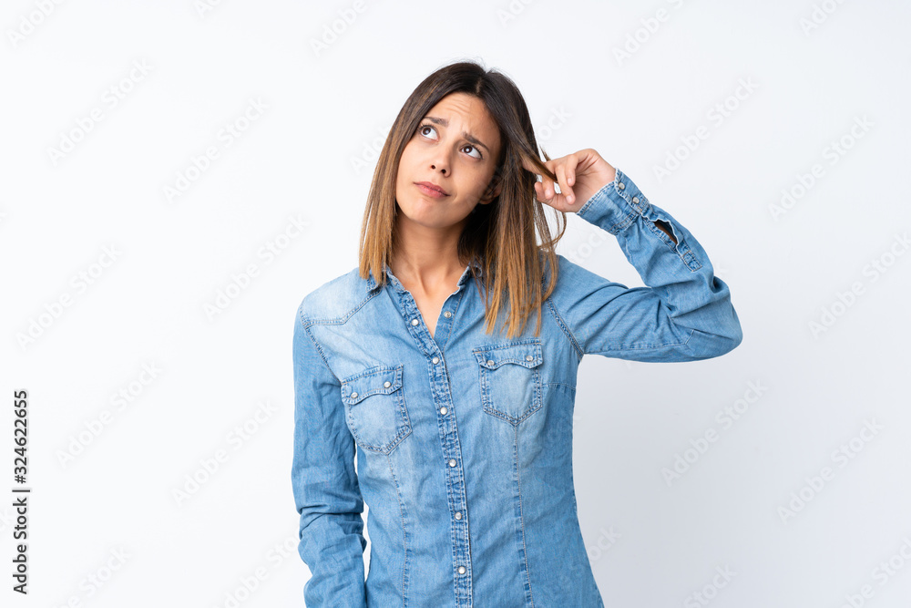 Young woman over isolated white background making the gesture of madness putting finger on the head Young woman over isolated white background making the gesture of madness putting finger on the head