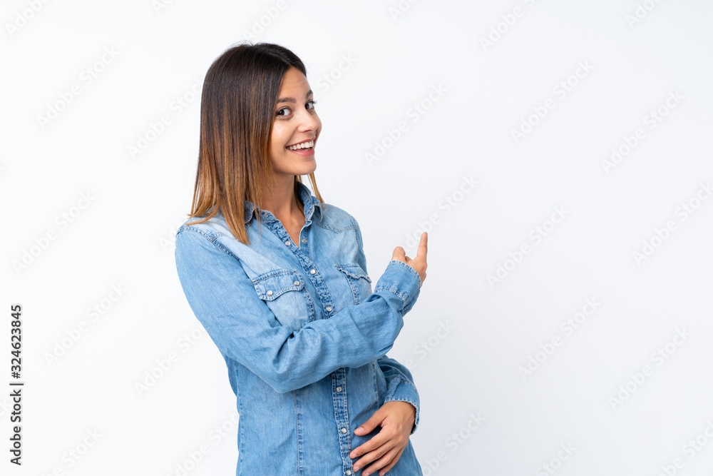 Young woman over isolated white background pointing back Young woman over isolated white background pointing back