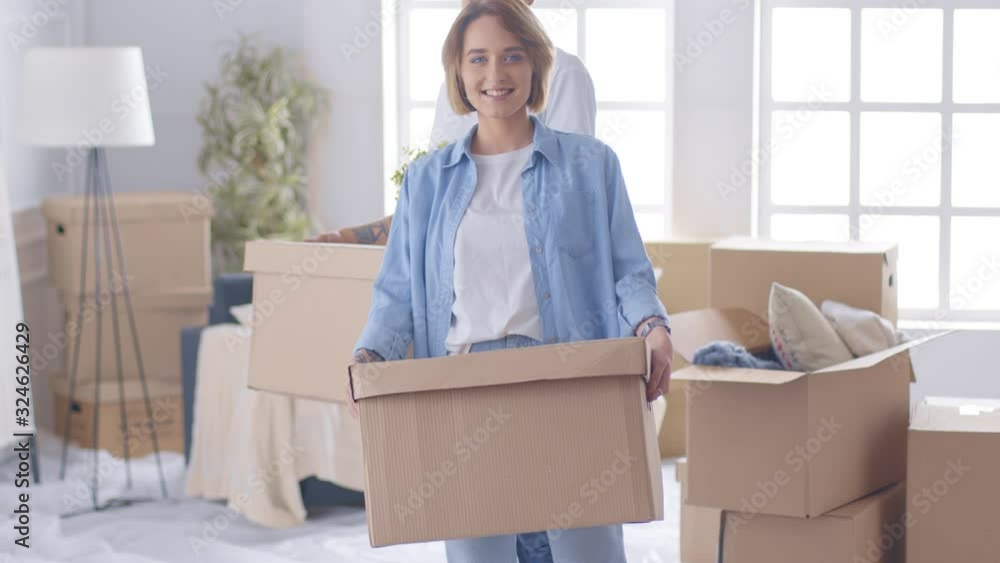 A young woman moving in new home, holding a box A young woman moving in new home, holding a box