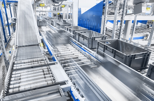 Modern conveyor system with boxes in motion, shallow depth of field. photo