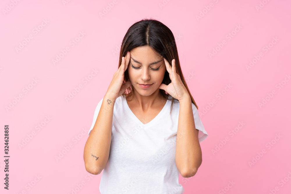 Young woman over isolated pink background with headache Young woman over isolated pink background with headache