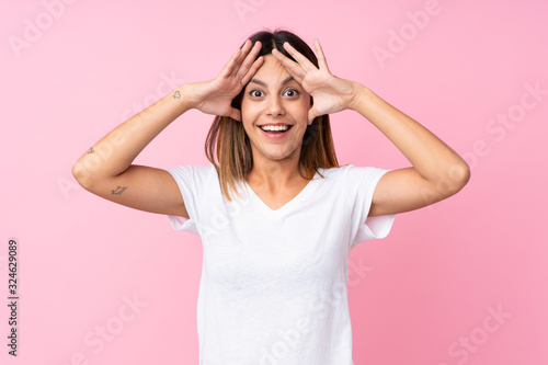 Young woman over isolated pink background with surprise expression