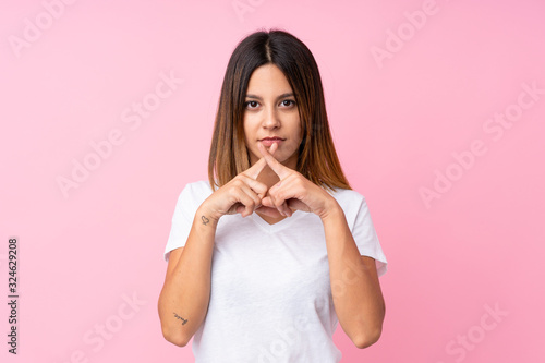 Young woman over isolated pink background showing a sign of silence gesture