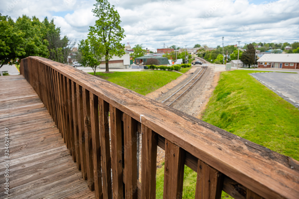 Footbridge crossing over railway, wood bridge for pedestrians, blur railroad and landscape