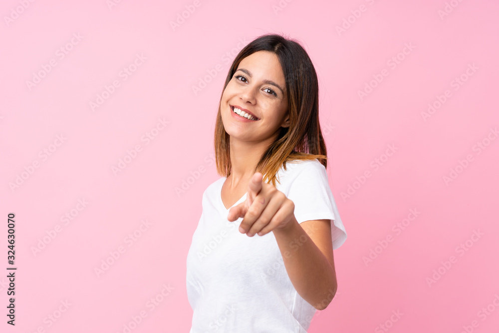 Young woman over isolated pink background points finger at you with a confident expression Young woman over isolated pink background points finger at you with a confident expression