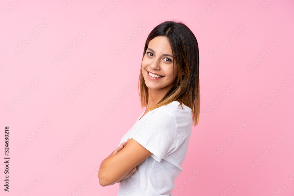 Young woman over isolated pink background with arms crossed and looking forward Young woman over isolated pink background with arms crossed and looking forward