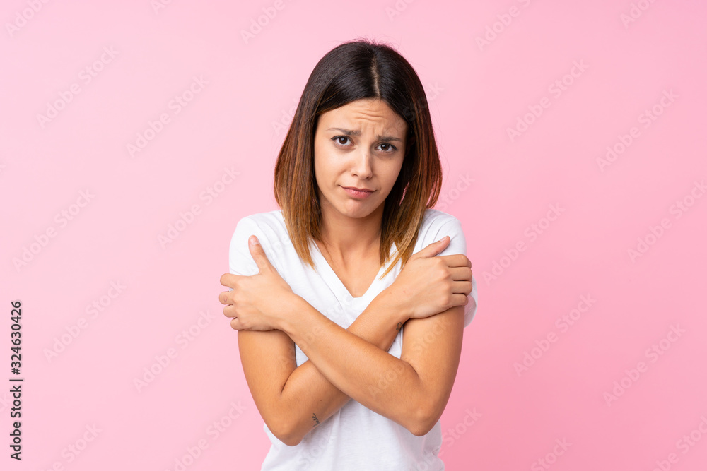 Young woman over isolated pink background freezing Young woman over isolated pink background freezing