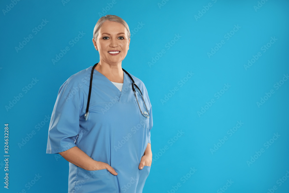 Portrait of mature doctor with stethoscope on blue background. Space for text Portrait of mature doctor with stethoscope on blue background. Space for text