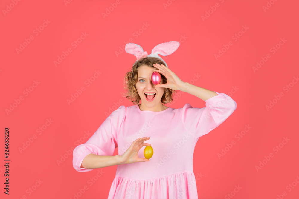 Happy Easter. Egg hunt. Girl holds color egg. Spring holiday. Smiling woman in rabbit bunny ears. Woman preparing for Easter. Hunts for Easter eggs. Easter celebration concept.