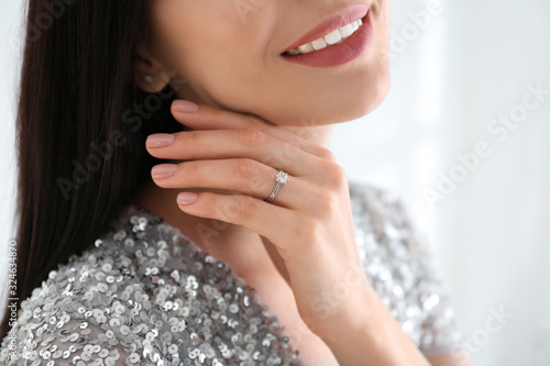 Young woman wearing beautiful engagement ring, closeup photo