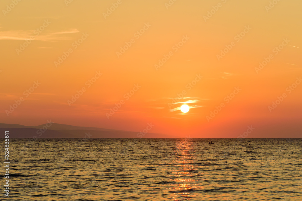 Fototapeta premium Beautiful sunset on the sea. Mediterranean sea at sunset, the town of Brela, Makarska Riviera, Dalmatia region, Croatia. Brela - seaside resort and popular holiday destination in Croatia