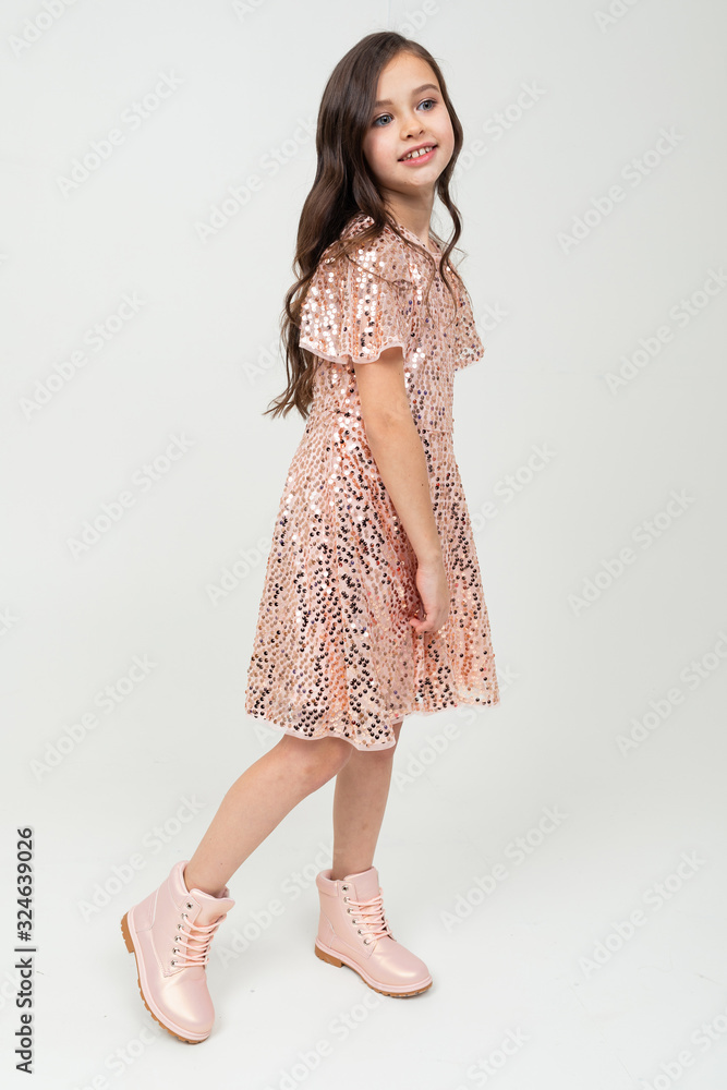 Full-length teenager girl in shiny party dress posing on a white studio background Full-length teenager girl in shiny party dress posing on a white studio background