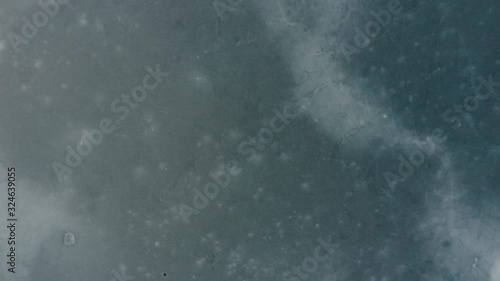 flying over a frozen ice on a reservoir, top view. winter lake. ice and debris.