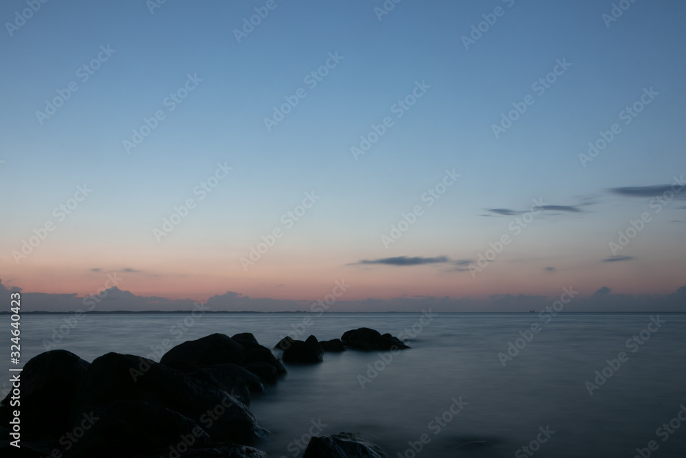 blue hour by the sea with rock silhouettes