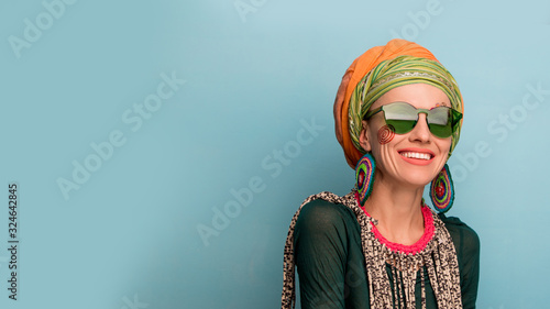 Beautiful woman with a turban on her head, fashion earrings and a bracelet. Africa style woman concept	