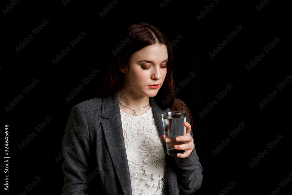 Portrait of a woman drinking water. Smiling girl. Portrait on a black background Portrait of a woman drinking water. Smiling girl. Portrait on a black background