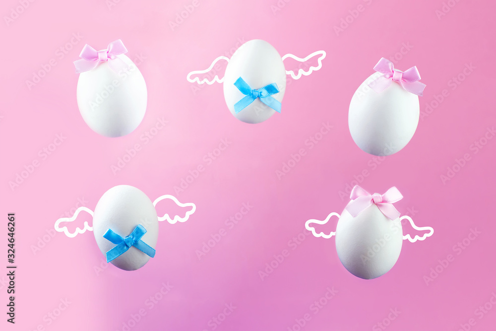Five eggs with wings and bows on a pink background. The concept for Easter.