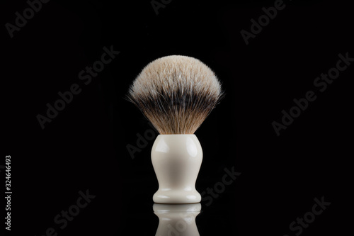 Traditional shaving brush in front of black background. Shaving brush made of badger hair.