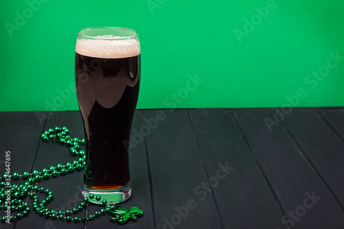 Canvas Print Glass of dark stout beer and traditional clover shaped decor