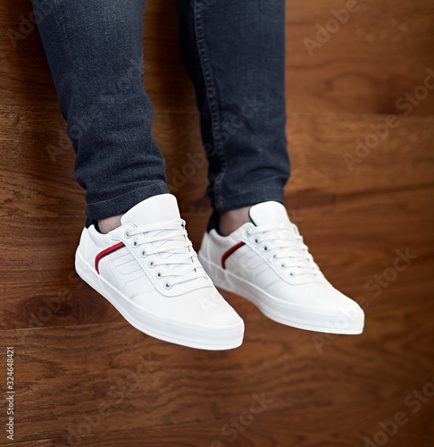 white shoes with red and blues stripe hanging down on the wooden background