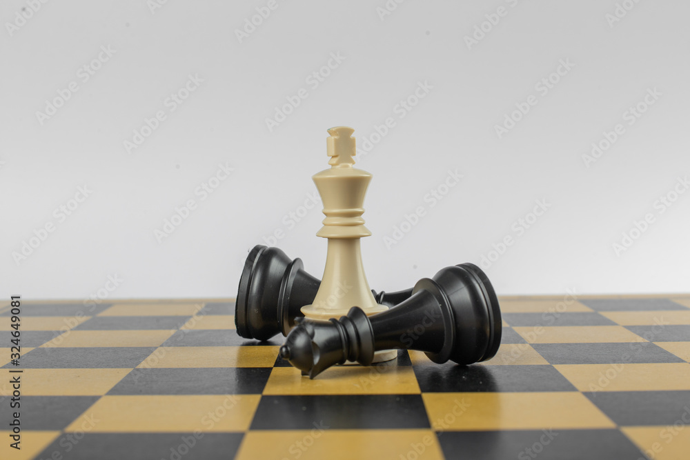 White figure in the center and blacks around on a chessboard on isolated white background White figure in the center and blacks around on a chessboard on isolated white background