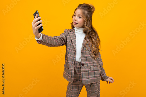 girl in classic clothing style makes selfie on the phone in the studio