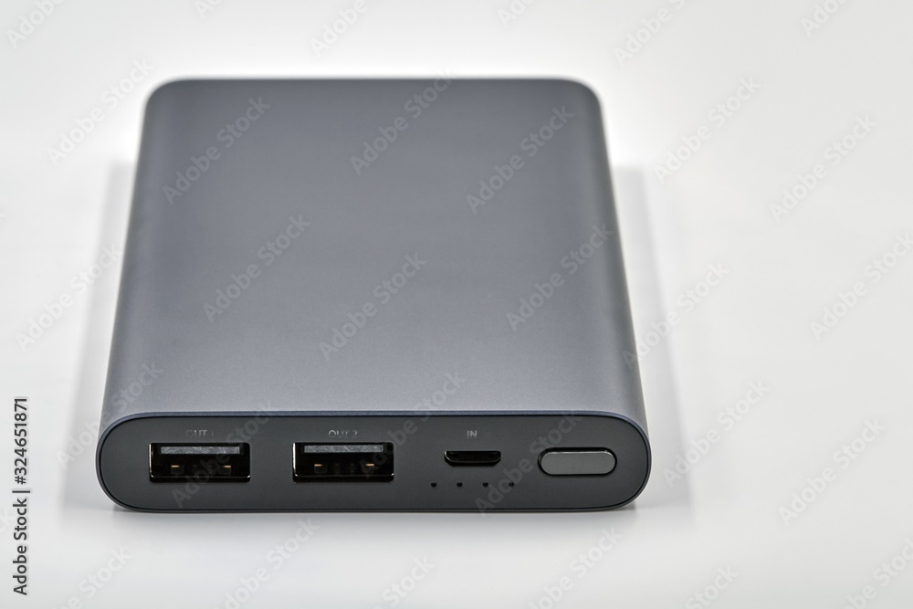 External dark powerbank with two usb outputs on a white background. Powerbank for charging mobile devices. Closeup External dark powerbank with two usb outputs on a white background. Powerbank for charging mobile devices. Closeup