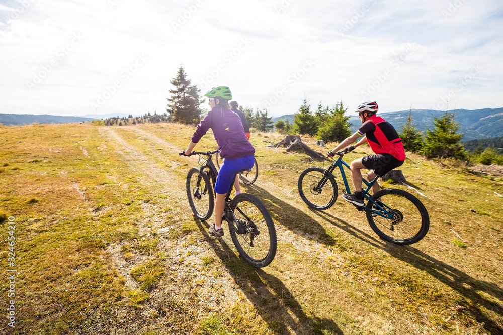 cyclists riding through mountain landscape in sunlight