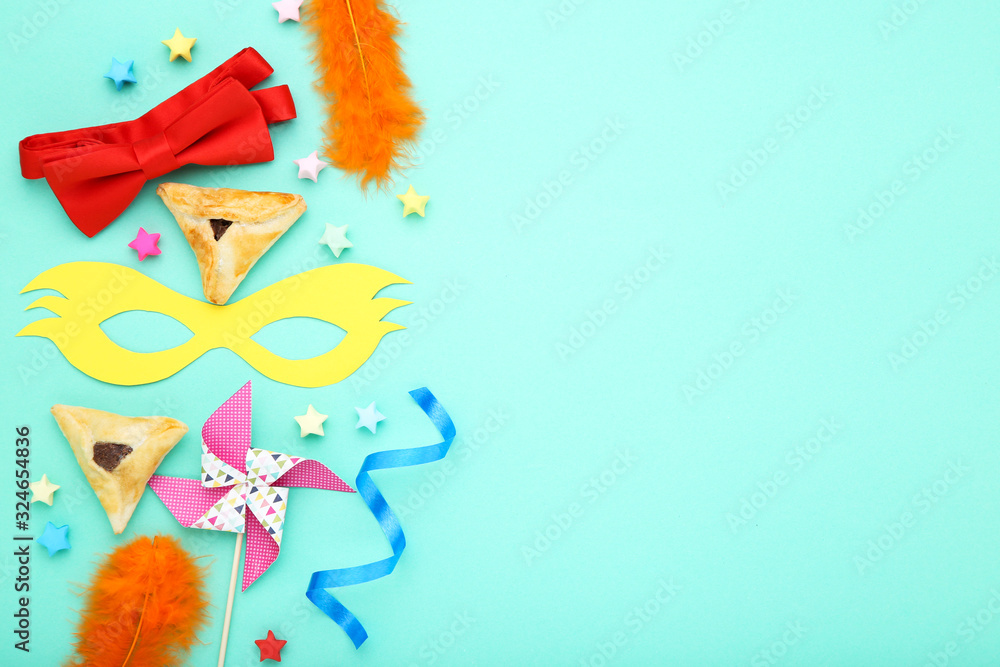 Purim holiday composition. Cookies with party supplies on blue background