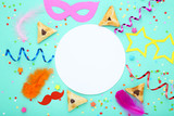 Purim holiday composition. Cookies with party supplies on blue background