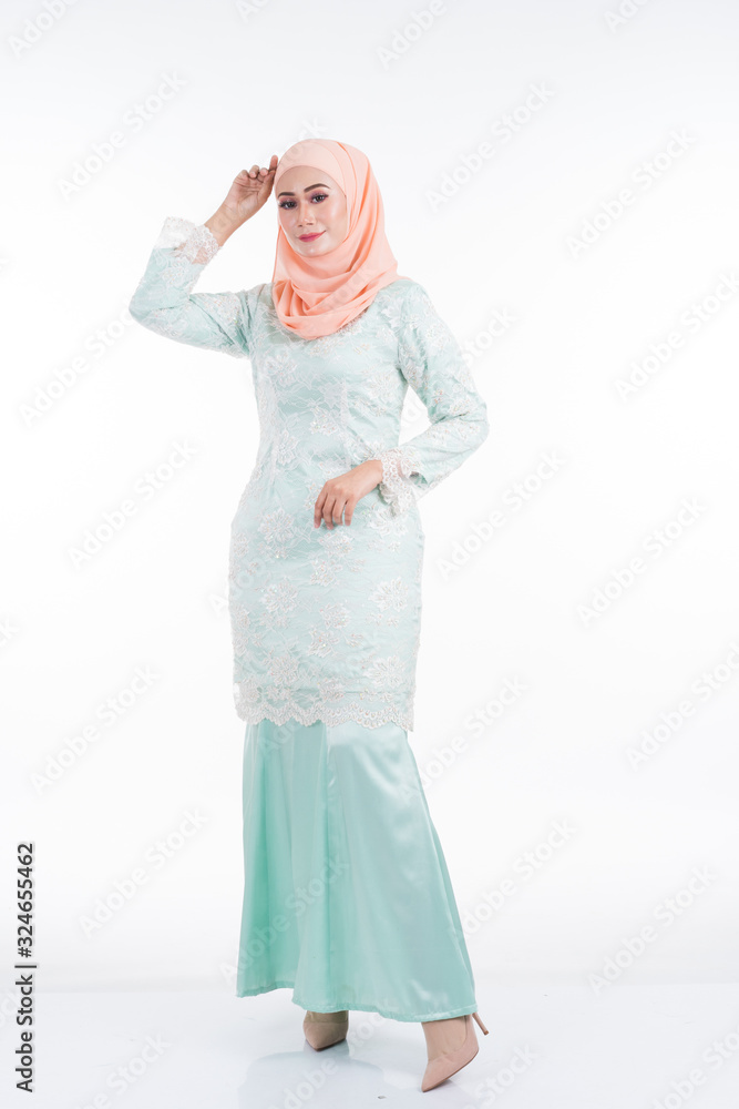 Beautiful female model in modern kurung and hijab, a modern lifestyle apparel for Muslim women isolated on white background. Beauty and hijab fashion concept. Full length portrait Beautiful female model in modern kurung and hijab, a modern lifestyle apparel for Muslim women isolated on white background. Beauty and hijab fashion concept. Full length portrait