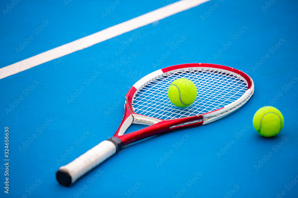 Close up view of tennis racket and balls on the clay tennis court (Selective Focus).