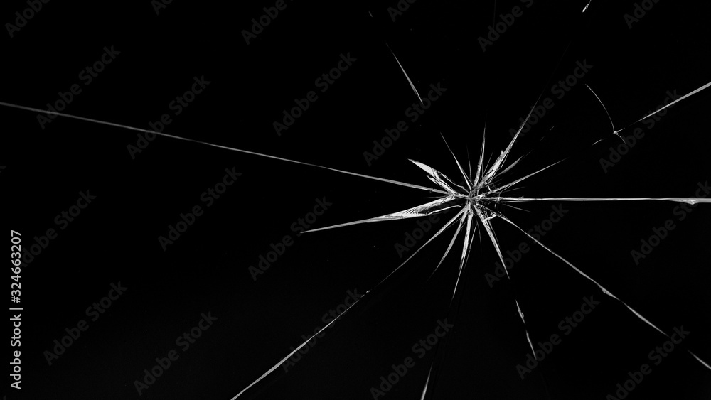 Fototapeta premium Round white cracks in glass on black background.
