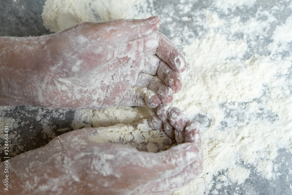 Fototapeta premium Hands in flour. Homemade cake. Cooking in the kitchen.