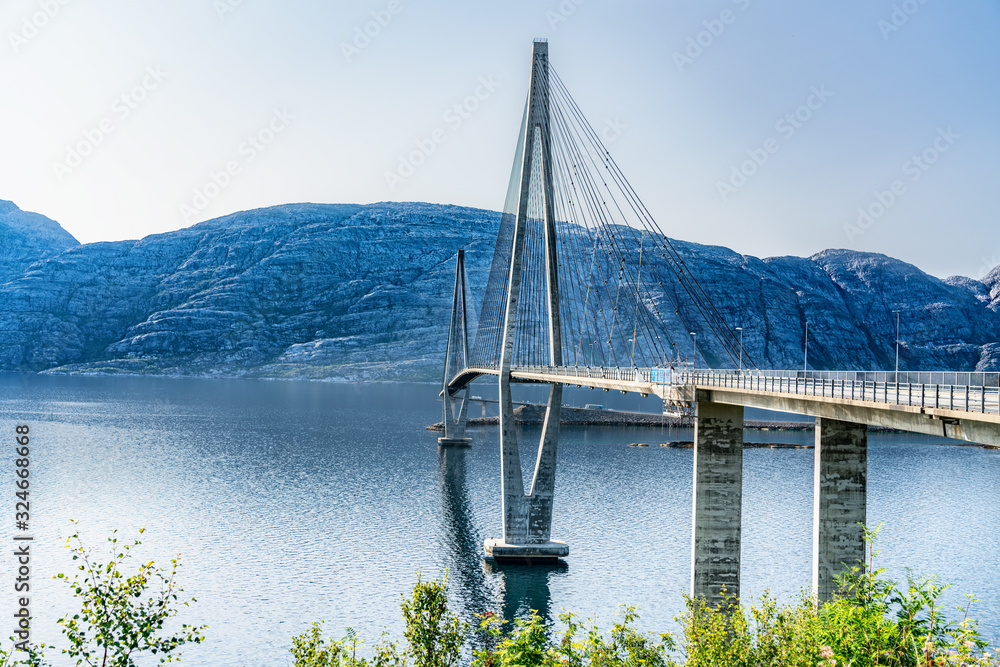 Dramatic sideview photo of Helgelandsbrua (norwegian) or Helgeland Bridge is Norway's finest bridges between Alstahaug and Leirfjord at Helgeland, Norway. Sunny, blue skies and quiet summer weather