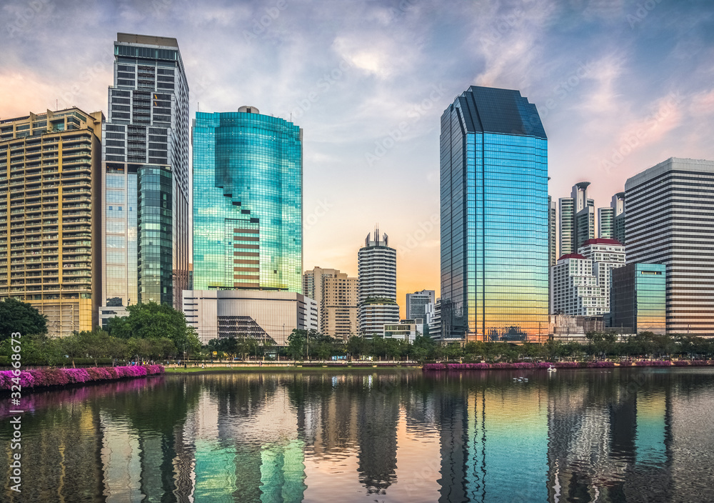 Fototapeta premium Wieżowce odbite w jeziorze o zmierzchu. Benjakiti Park w Bangkoku w Tajlandii