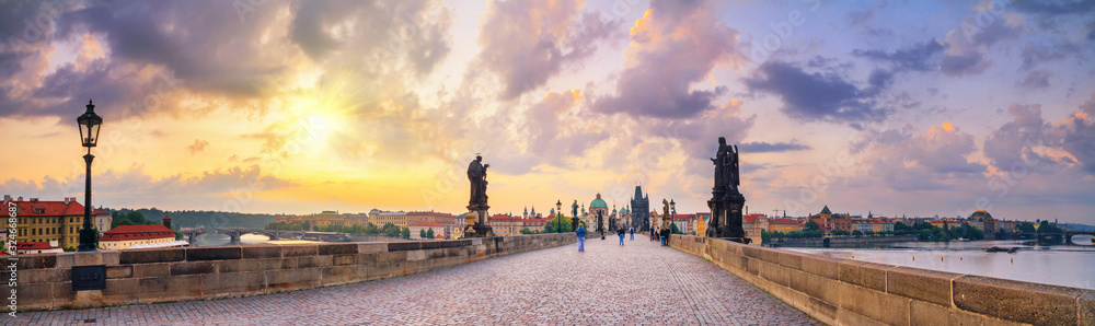 City summer landscape at sunrise - view of the Charles Bridge in historical district of Prague, Czech Republic