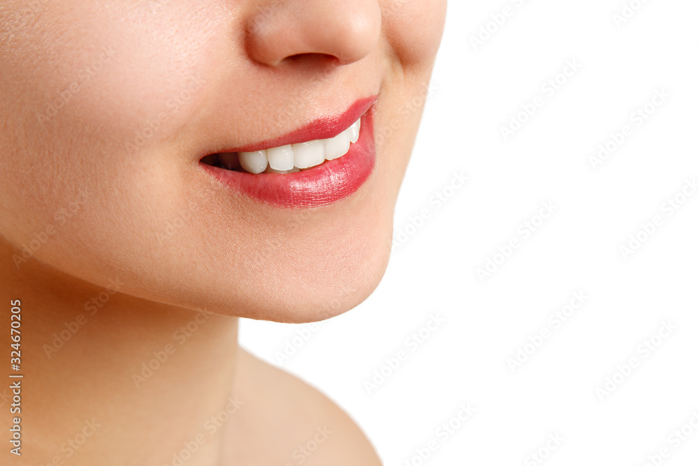 Obraz premium the smile of a young woman with perfect white teeth. close-up isolated on white background. place for copy space