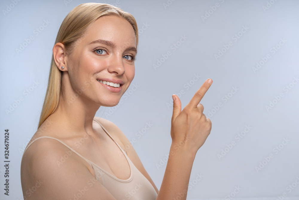 Positive delighted young woman looking straight at camera Positive delighted young woman looking straight at camera