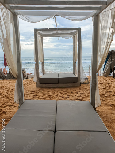 Beautiful image of sunbeds with canopy on the ocean beach