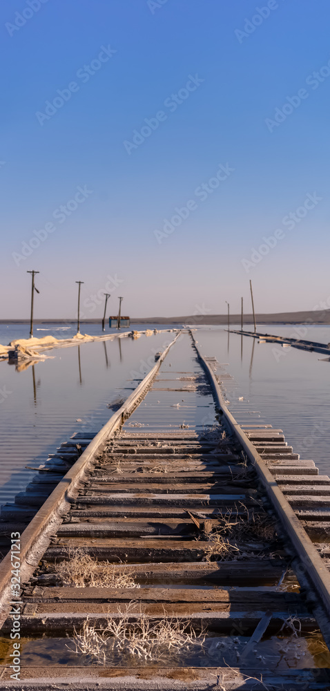 old rails sunk in water against a blue sky old rails sunk in water against a blue sky