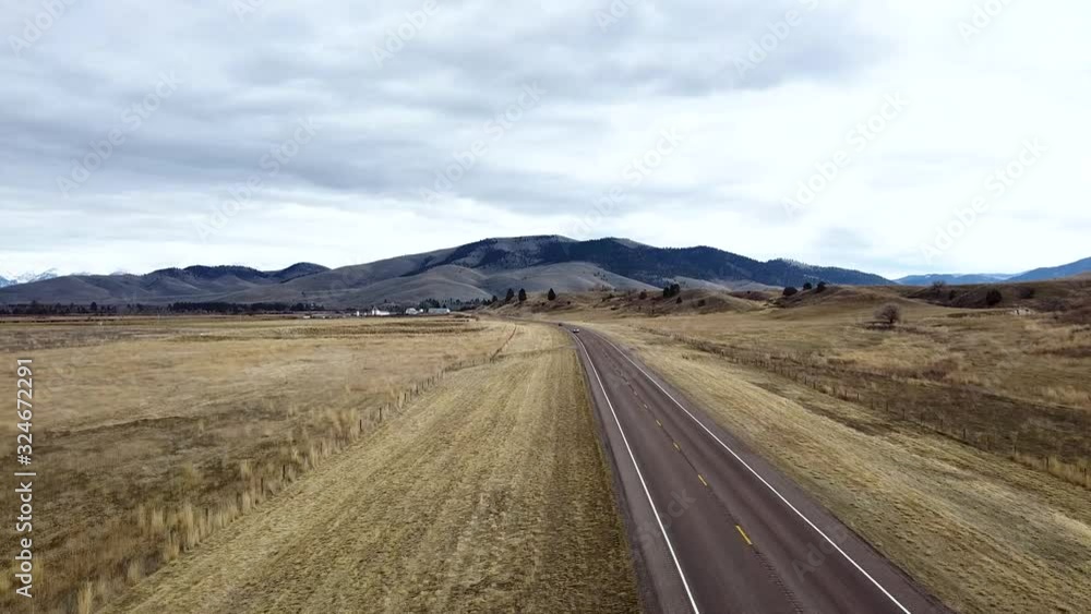 Overhead shot down a rural highway toward tree covered rolling hills with cars passing Overhead shot down a rural highway toward tree covered rolling hills with cars passing