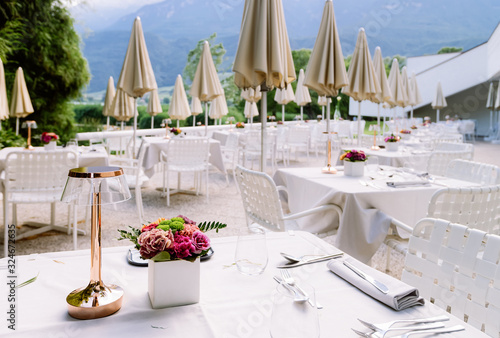 Luxury street restaurant with white tablecloth and flowers at Caldaro Lake of Italy photo