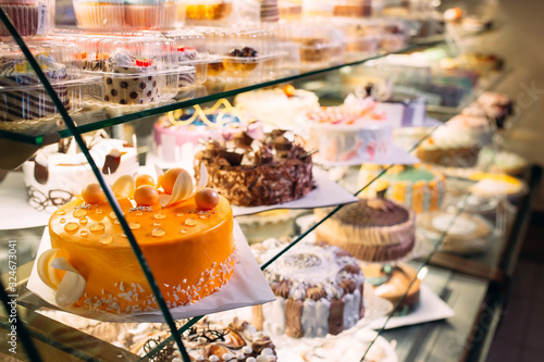 Vászonkép Pastry shop glass display with selection of cream or fruit cake.