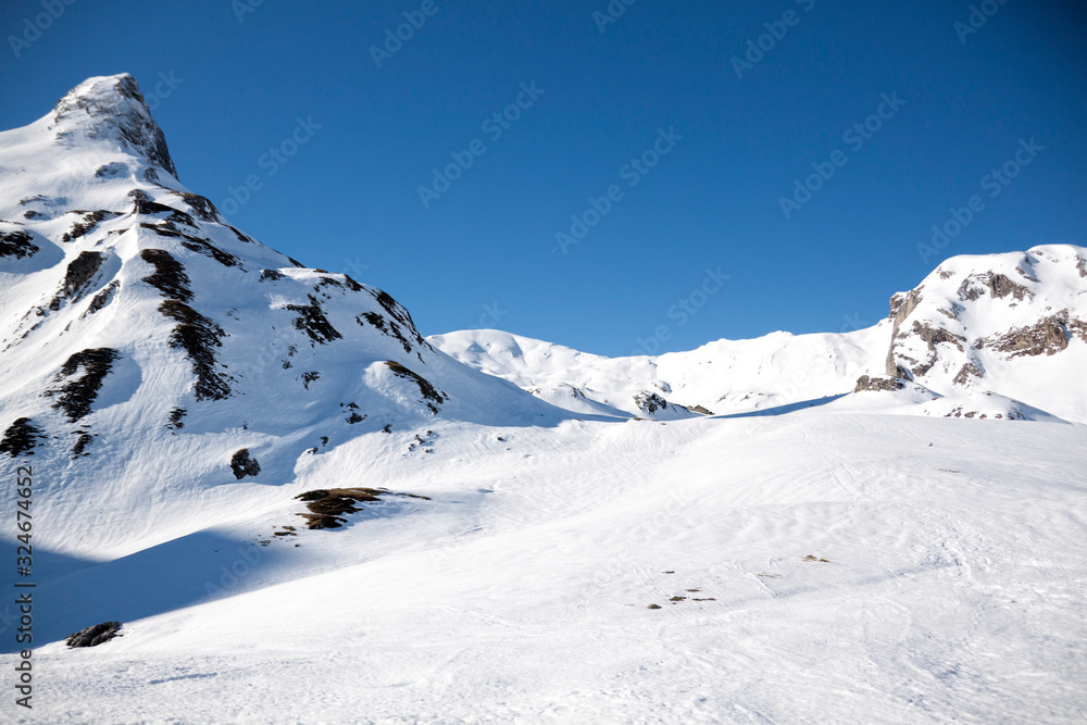 valley surrounded of mountains in a sunny day covered of snow