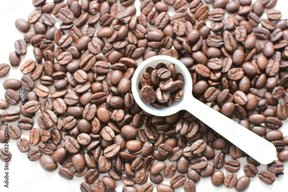 Fototapeta premium Processed coffee beans and tostao, on wooden background